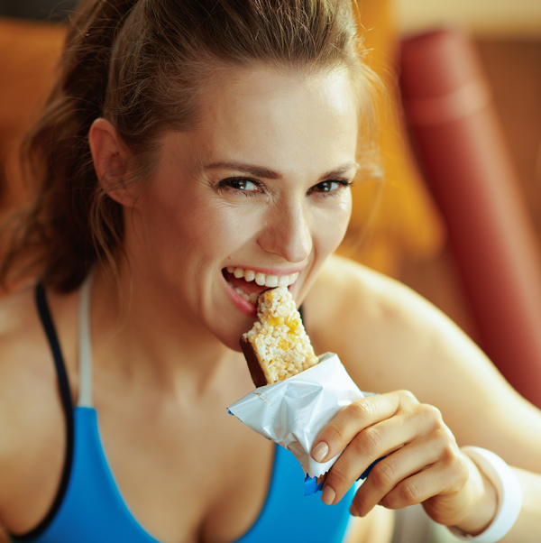 Femme qui mange une barre nutritionnelle